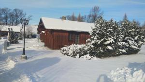 a red cabin in the snow with snow covered trees at Chata 412 Tatralandia in Liptovský Mikuláš