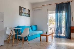 a living room with a blue couch and a table at Kapahi Magic Hotel Apartments in Potos