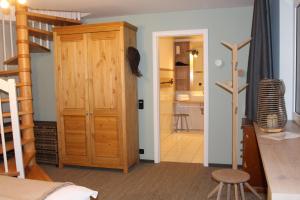 a bedroom with a wooden closet and a staircase at FerienWohnung SeeUfer am Plöner See in Ascheberg