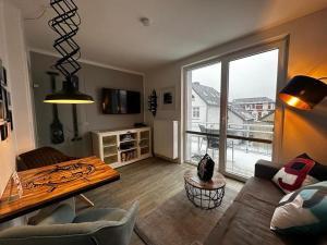a living room with a couch and a large window at Bootshaus Appartements in Cuxhaven
