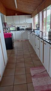 a kitchen with white cabinets and a tile floor at Guest house Winklespruit in Kingsborough