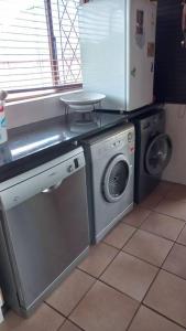 a kitchen with a washing machine and a refrigerator at Guest house Winklespruit in Kingsborough
