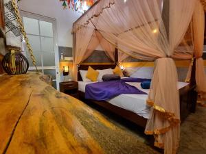 um quarto com uma cama de dossel e cortinas em Thara Cabana em Bentota