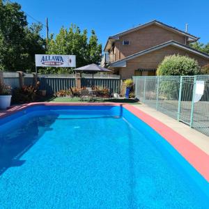 a swimming pool in front of a house at Albury Allawa Motor Inn in Albury