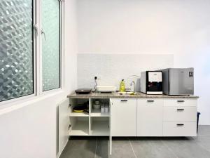 a kitchen with white cabinets and a counter top at Langkawi Seaview Cube w/ Rooftop Pool in Kuah