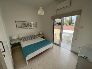 a bedroom with a bed and a sliding glass door at Themis Apartments in Larnaka