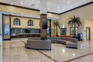 a lobby of a hotel with couches and palm trees at Ramada Plaza by Wyndham Marco Polo Beach Resort in Miami Beach
