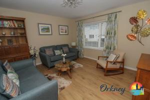 Algarth, Stromness, Orkney - OR00218F في سترومنيس: غرفة معيشة مع أريكة وطاولة