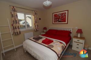 a bedroom with a bed with red pillows and a window at Algarth, Stromness, Orkney - OR00218F in Stromness