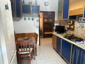 a kitchen with a table and a kitchen with blue cabinets at Appartamento al mare in Porto Santo Stefano