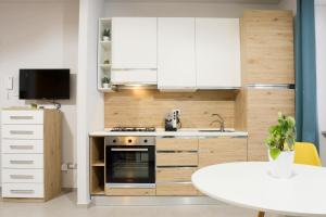 a kitchen with a stove and a sink and a table at Le stanze di Mami in Salerno