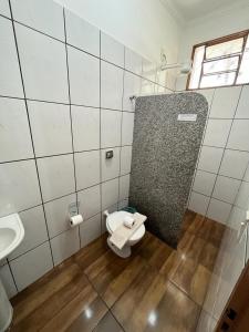 a bathroom with a toilet and a sink at Hotel Portela II in Olímpia