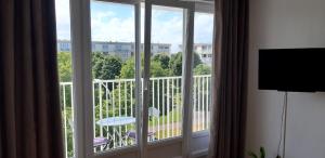 a room with a window with a view of a balcony at Appartement lumineux idéalement situé à proximité de musées équipements sportifs salle de spectacle commerces in Caen