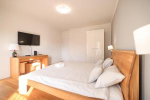 um quarto com uma cama branca e uma televisão em Sunset Boutiqe Apartment Old Town Zadar em Zadar