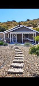 une maison avec un chemin en pierre menant à celle-ci dans l'établissement Girasoles de Valdes, à Puerto Pirámides