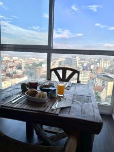 una mesa de madera con comida delante de una ventana en Hotel Le Pousse Pousse, en Antananarivo