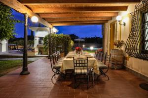 einen langen Tisch mit Stühlen auf einer Terrasse in der Unterkunft Villa Colombai in Orentano