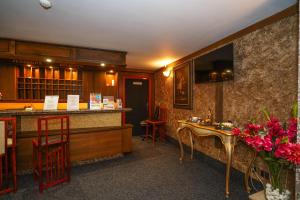 a restaurant with a counter and a bar with red stools at Hotel Central Club Sofia in Sofia