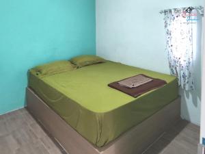 a green bed in a room with a curtain at Rumah Teman Hostel in Semarang