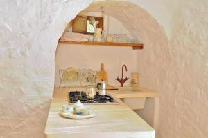 a kitchen with a counter with a sink and a stove at Trullo Fragnelli in Cisternino