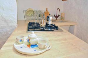 a kitchen counter with two tea cups and a stove at Trullo Fragnelli in Cisternino