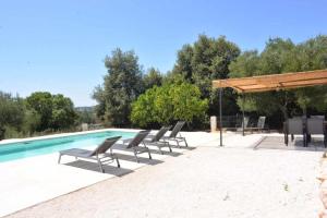 a group of chairs sitting next to a swimming pool at Trullo Fragnelli in Cisternino