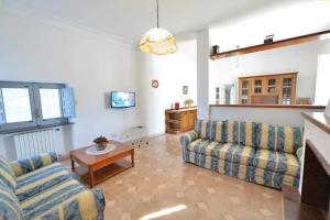 een woonkamer met 2 banken en een tafel bij Villa Giovanna Trullo in Ostuni