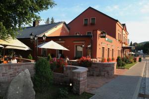 un bâtiment avec un café en plein air et un parasol dans l'établissement Penzion Poříčí, à Trutnov