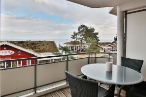 沙博伊茨Residenz Ostseestrand Appartement 17的配有桌椅并可欣赏海景的阳台