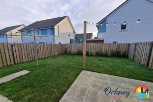 een tuin met een houten hek en een huis bij 18 Gold Drive, Kirkwall, Orkney - OR00185F in Orkney +2 foto's