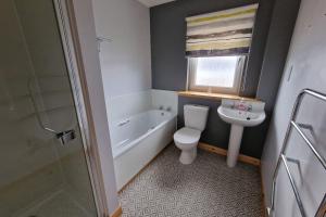 a bathroom with a toilet and a sink and a bath tub at 18 Gold Drive, Kirkwall, Orkney - OR00185F in Orkney