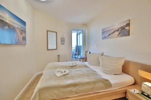 沙博伊茨Residenz Ostseestrand Appartement 22的卧室里有一张大床，床上铺着毛巾。 更多30张照片