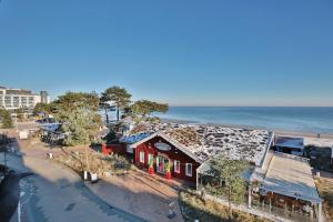 沙博伊茨Residenz Ostseestrand Appartement 22的海滩旁的一座红色小建筑