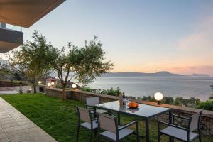 a table and chairs on a patio with a view of the water at Pietra Di Mare in Petres +40 photos