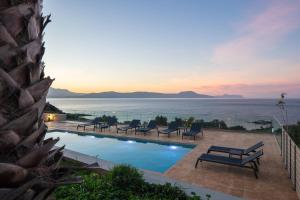 a pool with chairs and a view of the ocean at Pietra Di Mare in Petres