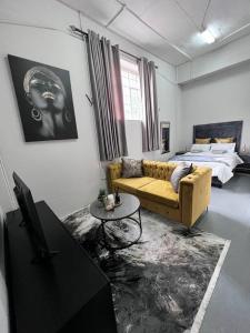 a living room with a couch and a bed at `Luxury Cosy City Apartment in Johannesburg