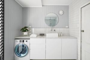 a white bathroom with a washing machine and a mirror at Circa 1890 in Melbourne +21 photos
