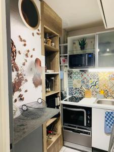 una cocina con fregadero y microondas en Rob’s Place - Paris Convention Center, en Vanves 10 fotos más