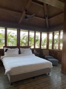1 dormitorio con 1 cama blanca grande y ventanas en Abode Bombay en Bombay