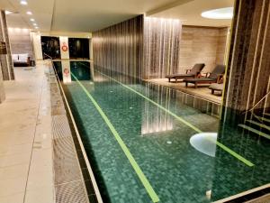 a large swimming pool in a hotel lobby at Luxe Waterfront Melbourne in Melbourne