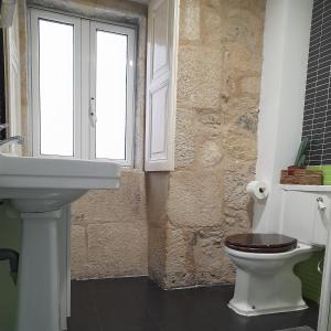 baño con aseo y lavabo y ventana en La Guinda Real, en Vigo