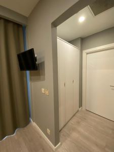 Habitación con armario, TV y puerta. en Li Hotel Pera, en Estambul