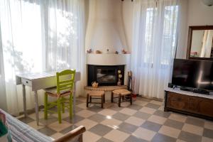 a living room with a desk and a fireplace at Traditional Stone House in Seafront Olive Grove A in Alyfantá