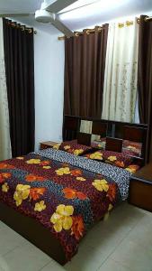 sypialnia z łóżkiem z kołdrą kwiatową w obiekcie Abo Amer Apartments w Akabie