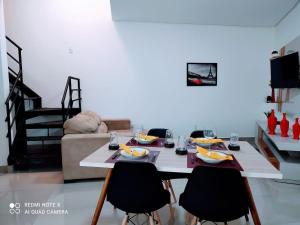 uma sala de estar com uma mesa com cadeiras e um sofá em Moria em Goiânia
