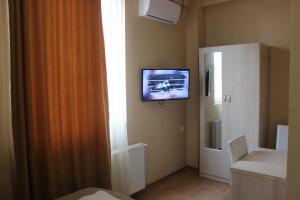 a room with a television on a wall with a window at Hotel Nikea in Kutaisi