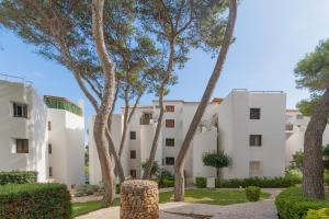 un edificio con delle palme di fronte di Apartamento Ferrera Park 305 a Cala Ferrera