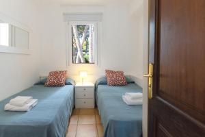 due letti singoli in una stanza con finestra di Apartamento Ferrera Park 305 a Cala Ferrera Altre 26 foto