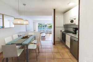 una cucina e una sala da pranzo con tavolo e sedie di Apartamento Ferrera Park 305 a Cala Ferrera