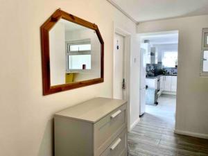 a bathroom with a mirror on the wall and a drawer at Fabulous, Spacious, Newly Refurbished Home close to Heathrow Airport in Hayes